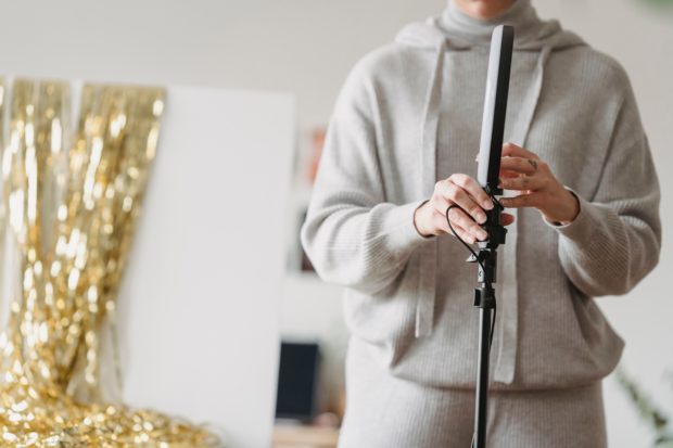 woman using ring light for home photography studio 