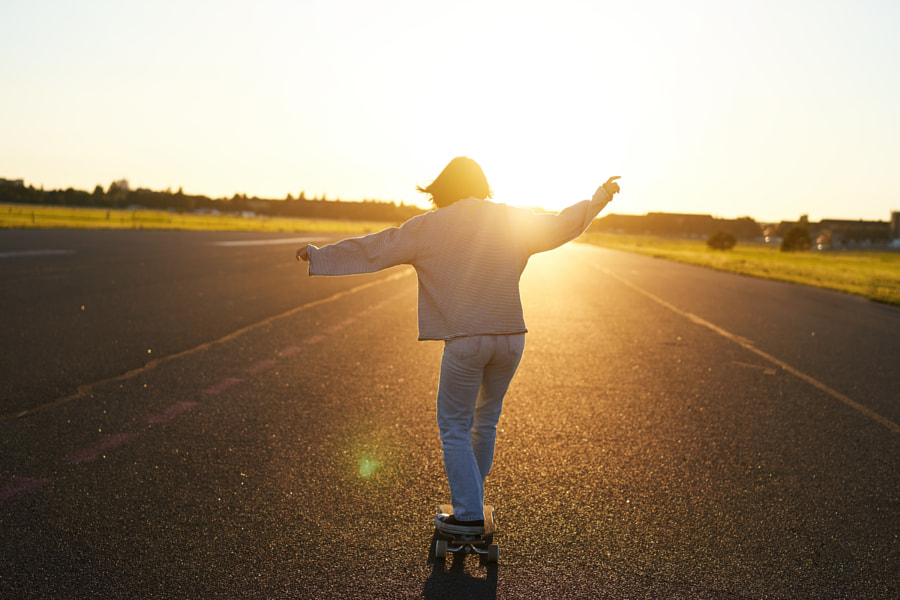 Teen girl feeling happy on longboard. Happy young skater riding her by Mix and Match Studio on 500px.com