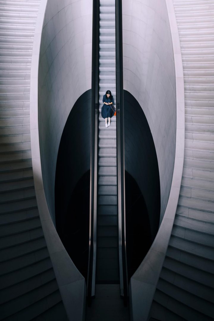 Aerial view of a woman sitting on the automatic stairs at Beijing Opera House, China