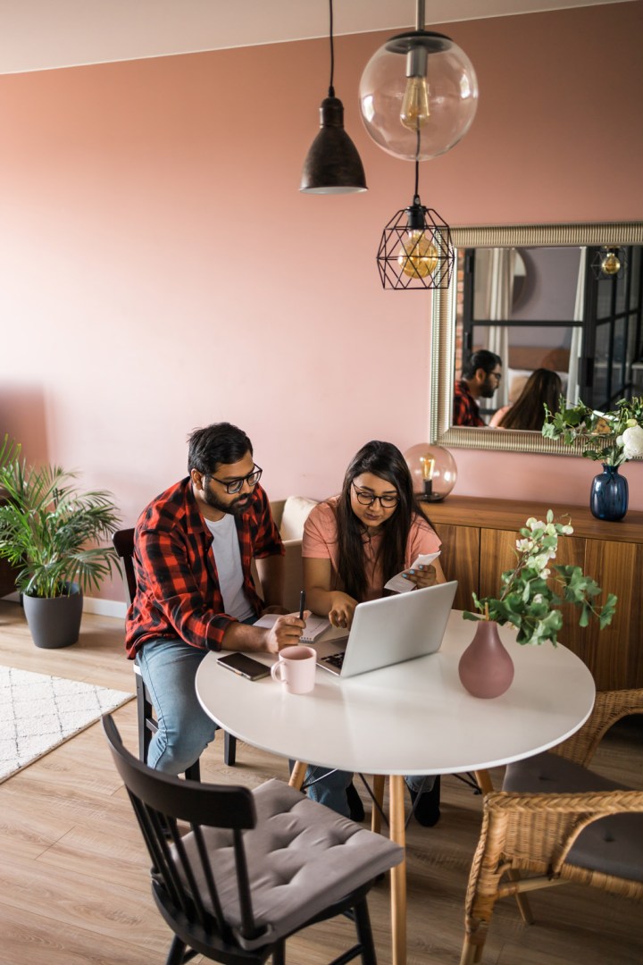 Serious wife and husband planning budget at kitchen table