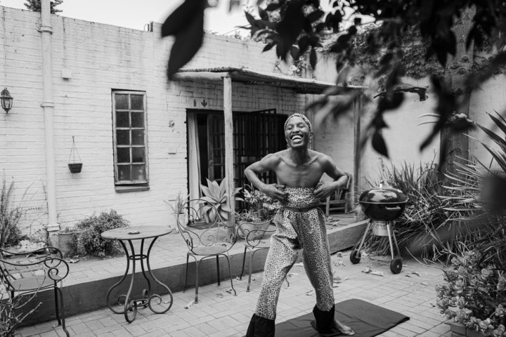 A queer identifying male practices yoga in the garden